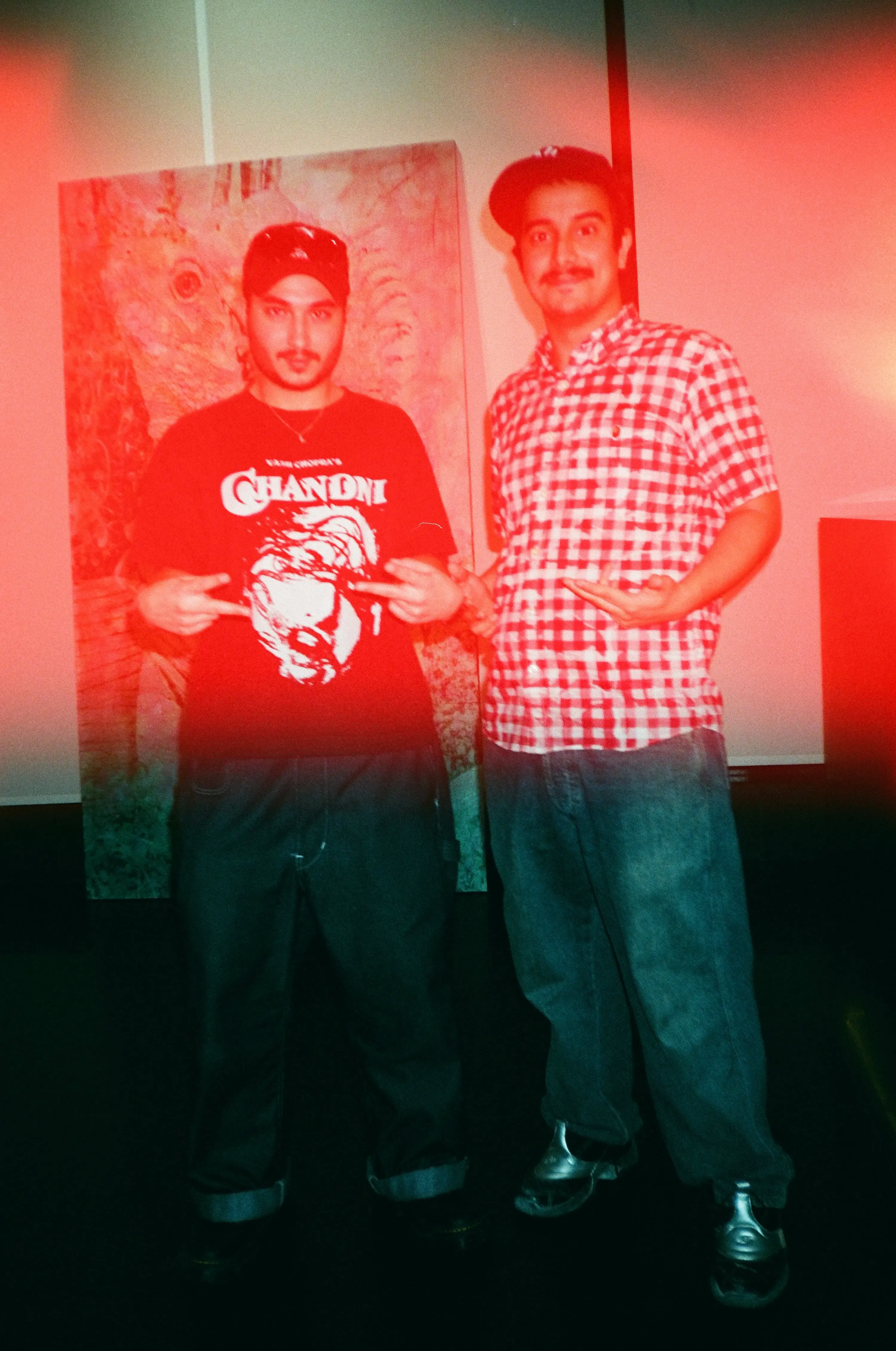 Talal Al Najjar and Salem Al Suwaidi posing together in front of one of the exhibited paintings