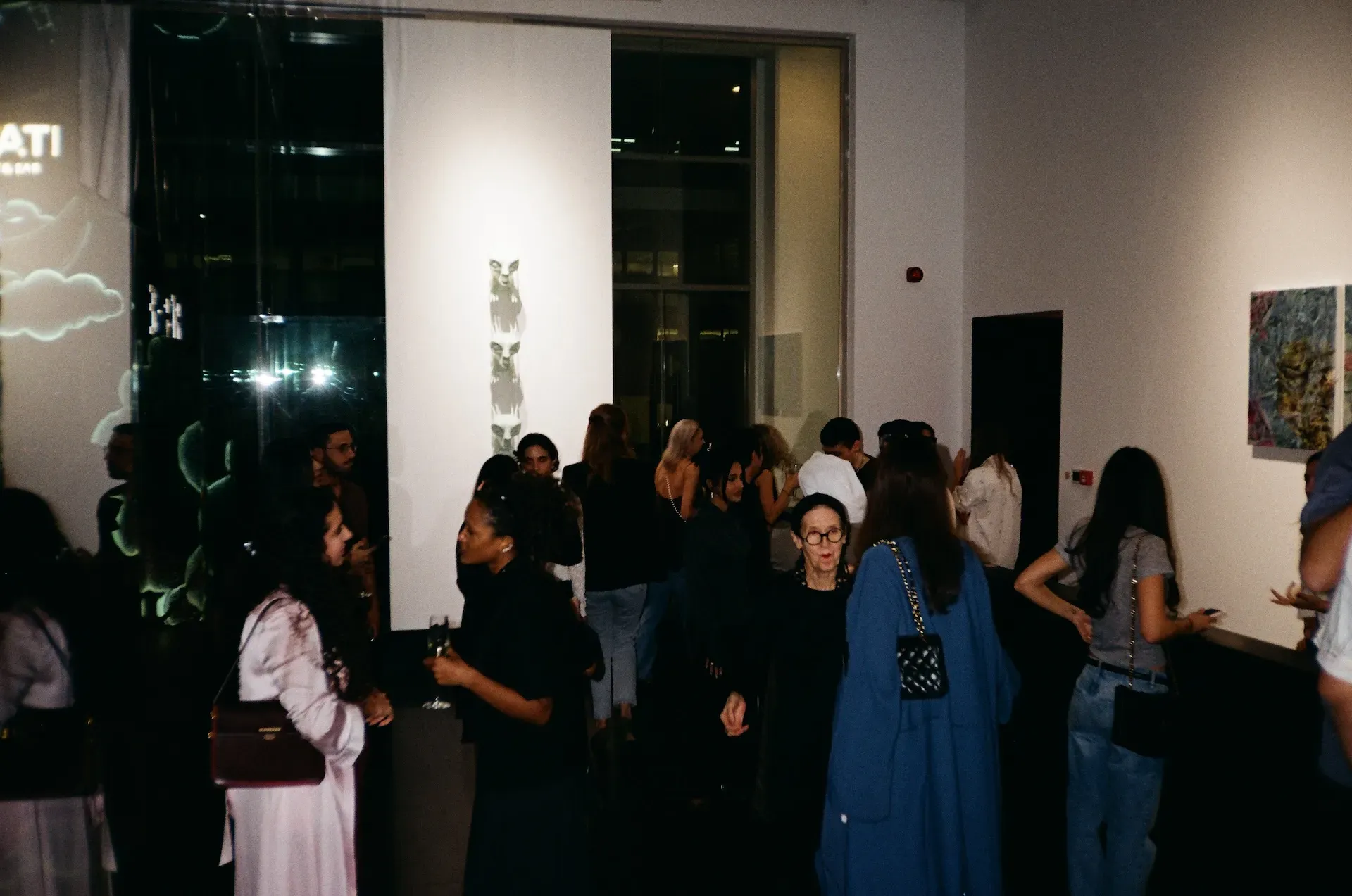 Guests gathered in a hallway beside a tall totem-like sculpture
