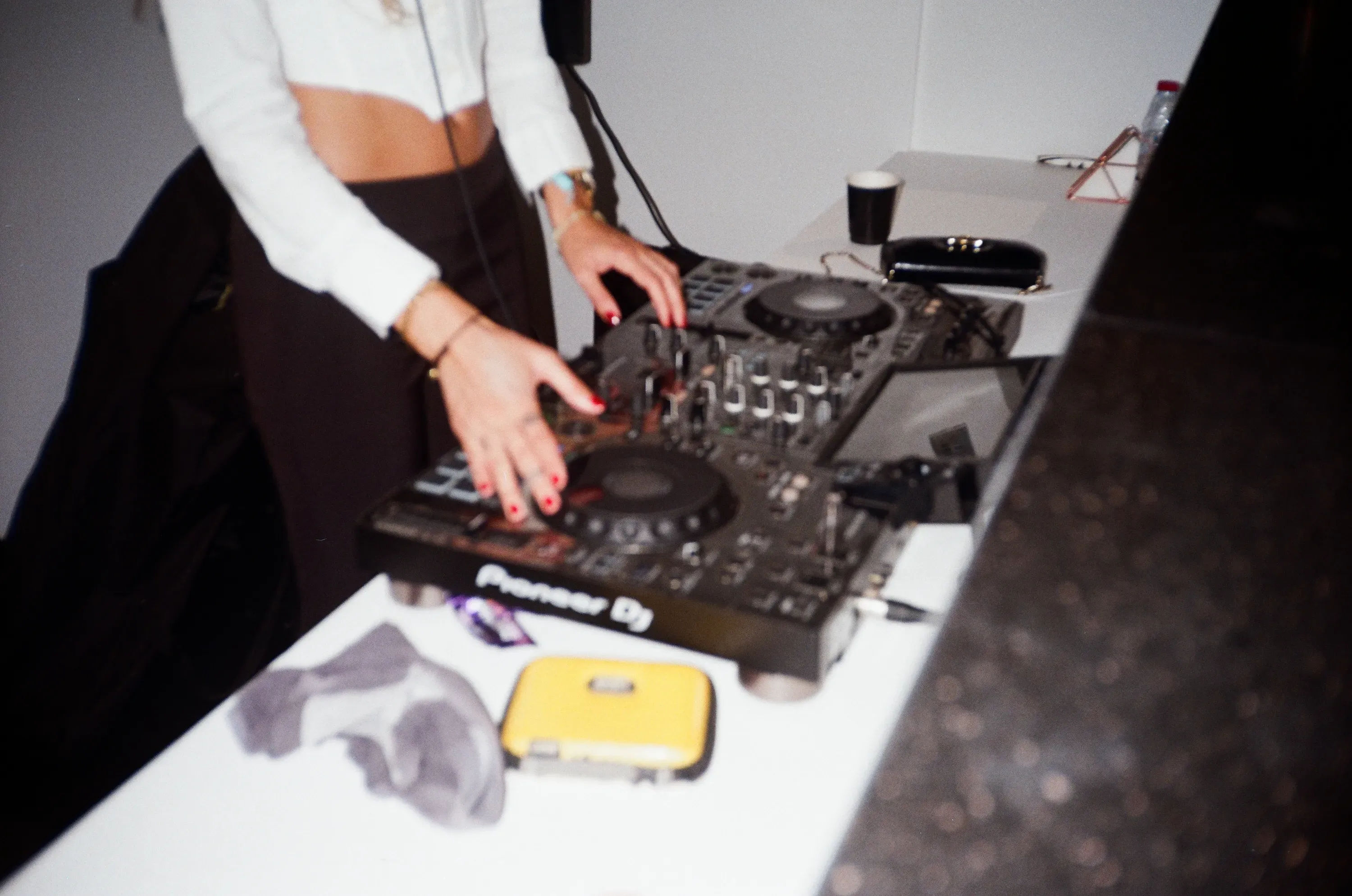 Close-up of the DJ's hands adjusting a Pioneer DJ mixer