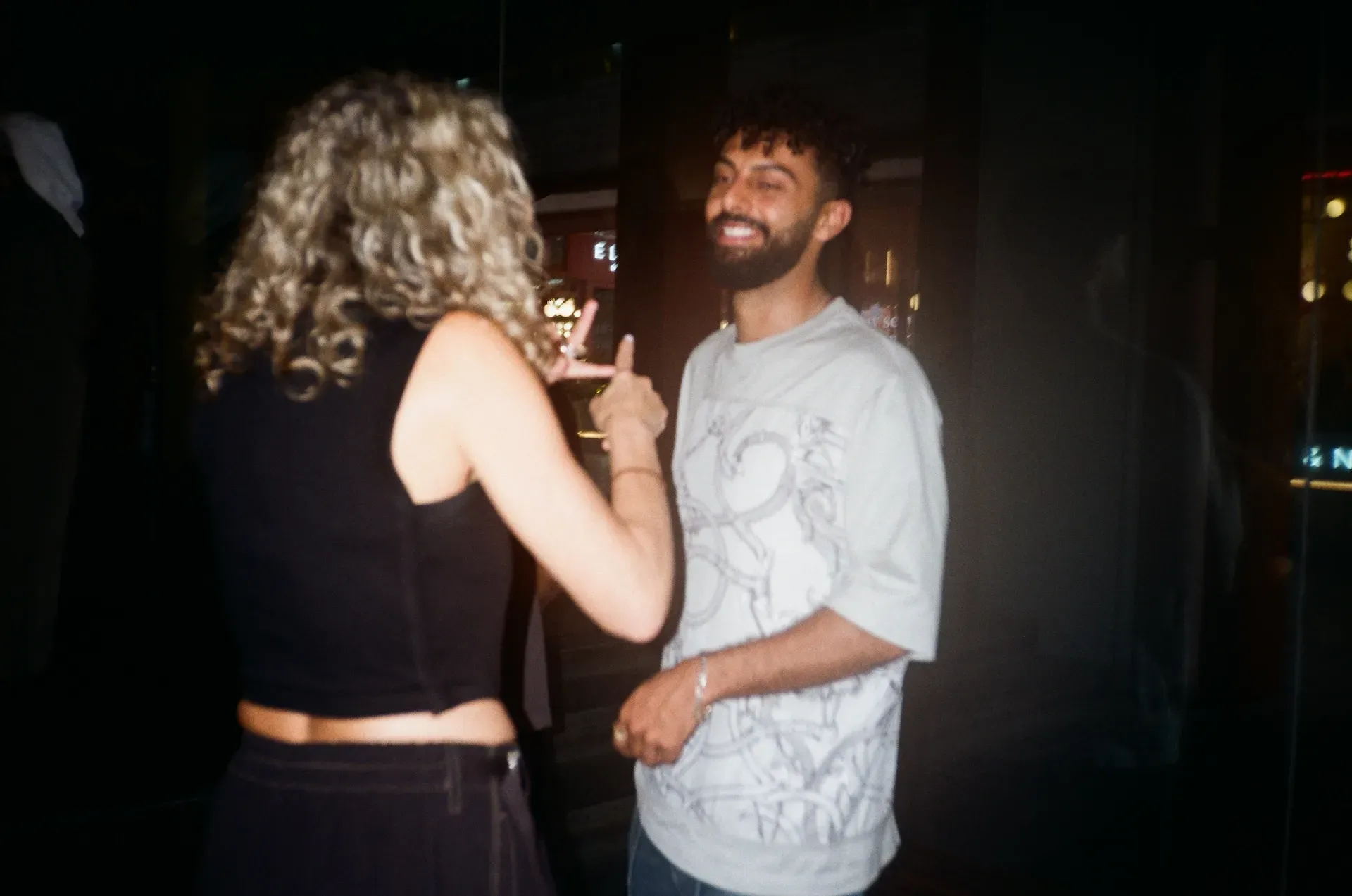 Two guests laughing together outside at night