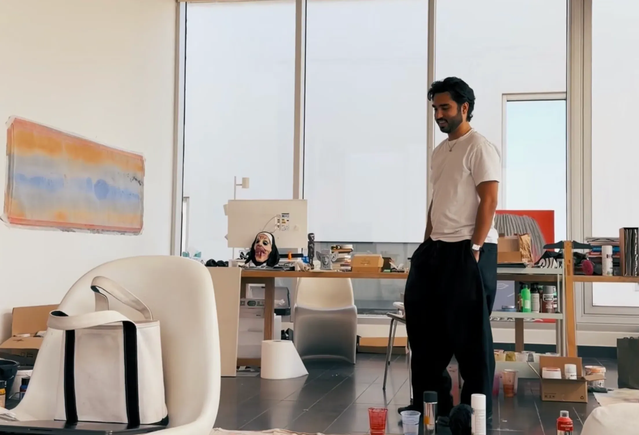 Ziad Al Najjar smiling in the studio, surrounded by paintings and materials